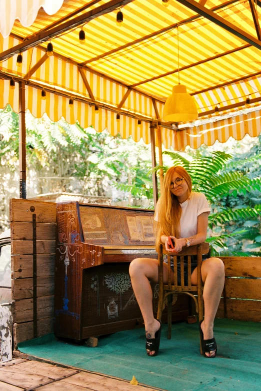 woman in white shirt sitting on chair with open umbrella