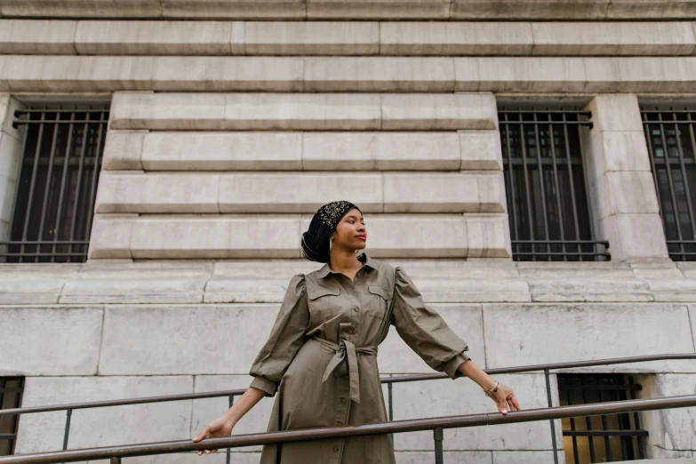 a woman is leaning against the rail of the stairs