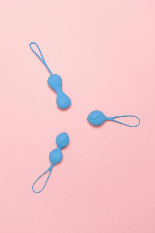 blue baby pacifiers sitting on pink paper