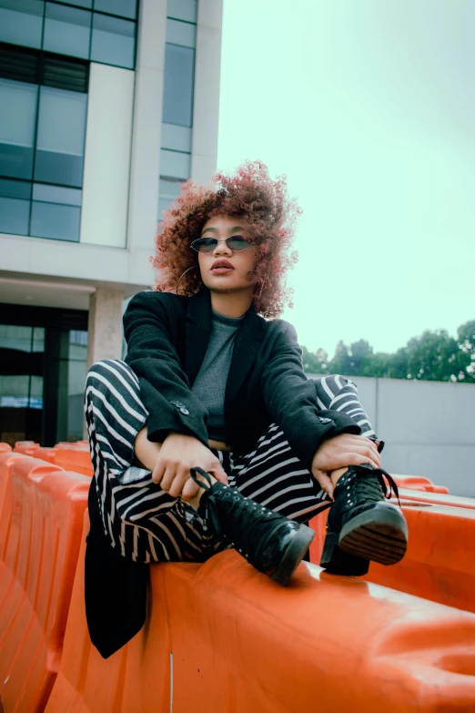 a red haired woman sitting on an orange tarp