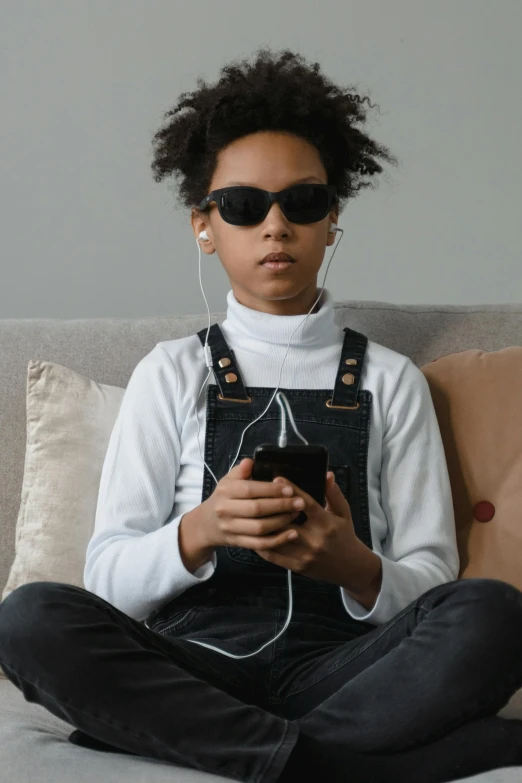 a woman wearing glasses is listening to music on her cellphone