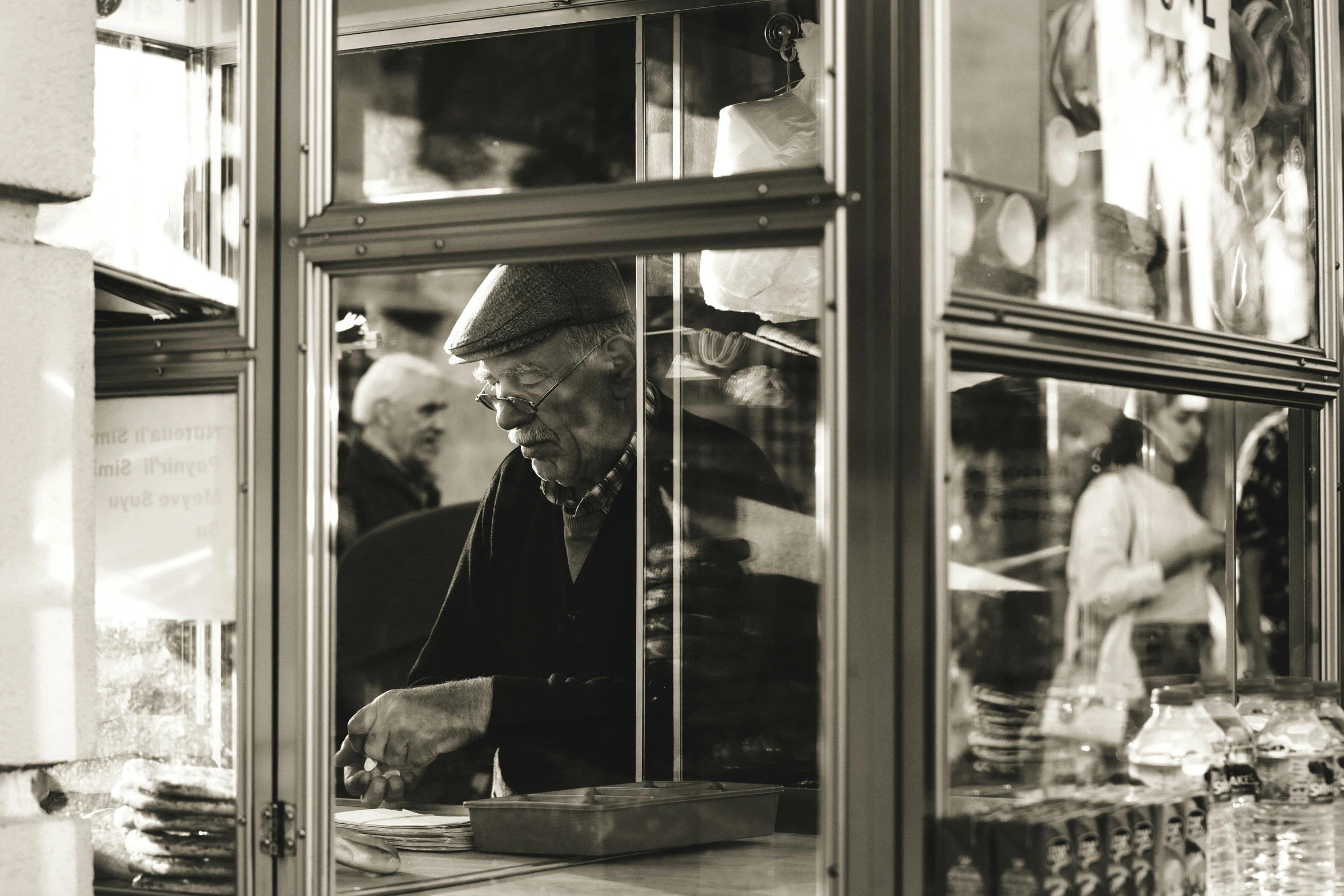 a man with a hat standing by a counter with several items