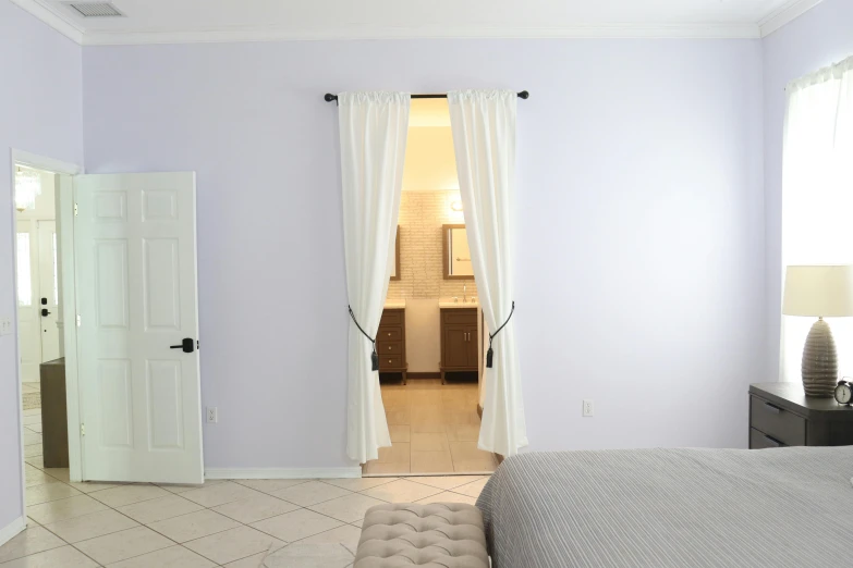 white curtains open onto a white bedroom