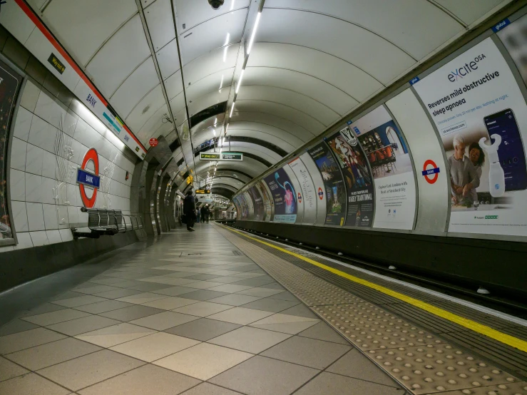 a subway tunnel with posters above it