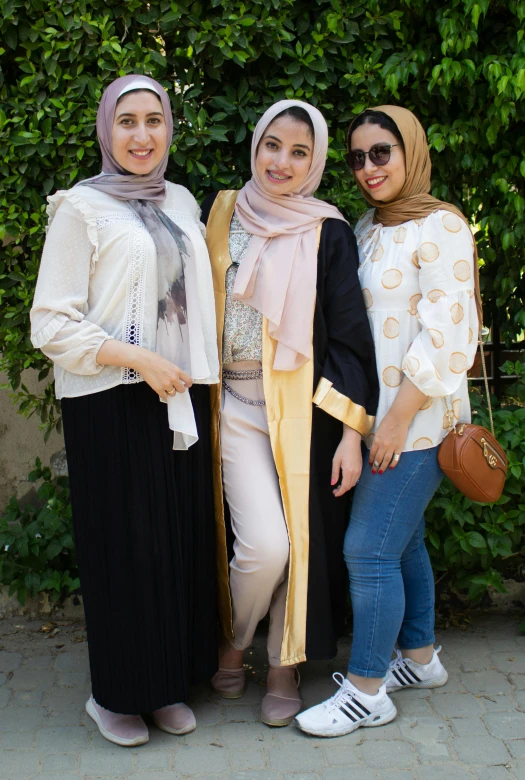 three women standing next to each other smiling for the camera