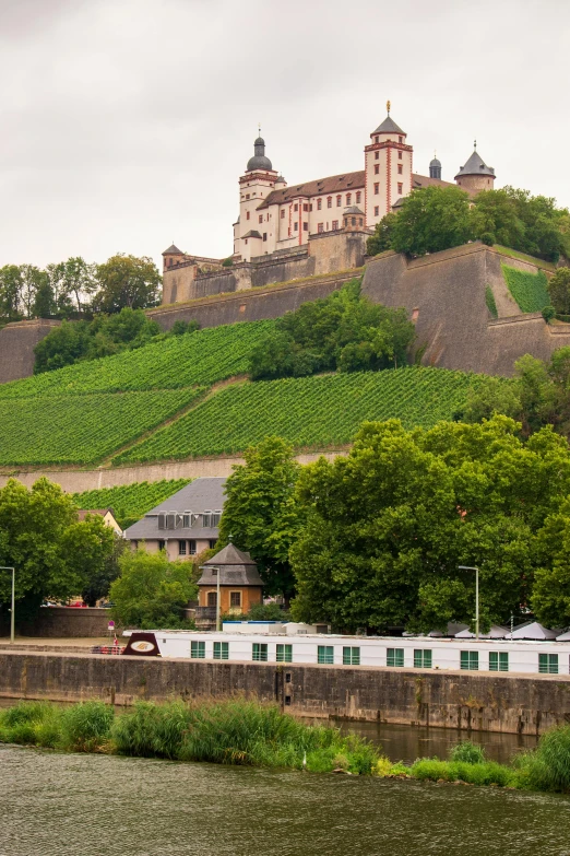 there is a train passing under a large castle