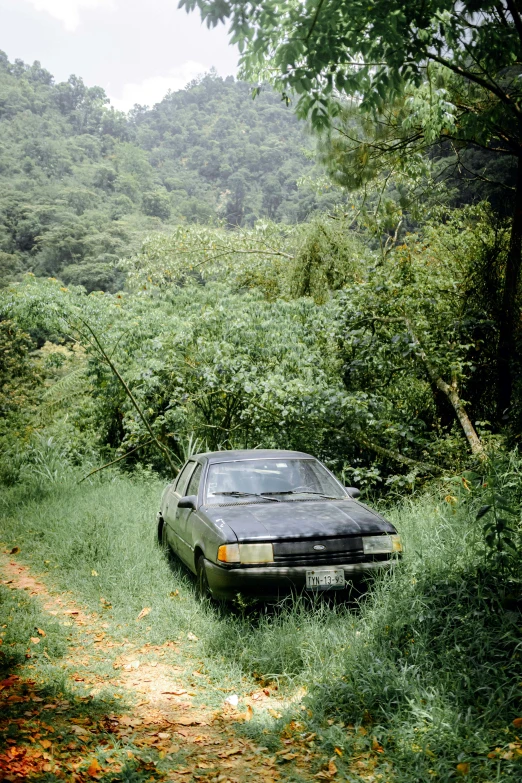 an old car in the middle of a grassy area