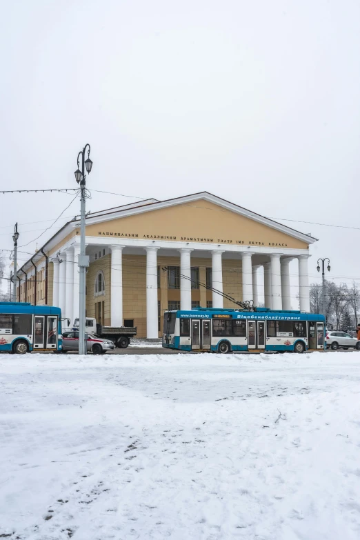 buses are parked in front of a large building