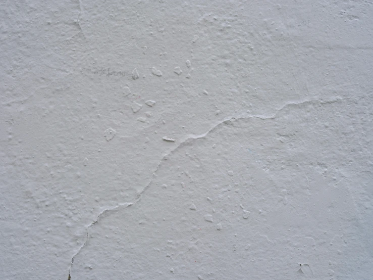 the wall is white with little scratches and light spots