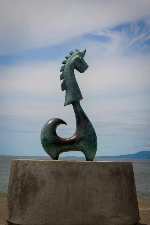 a statue of a snake in front of a body of water