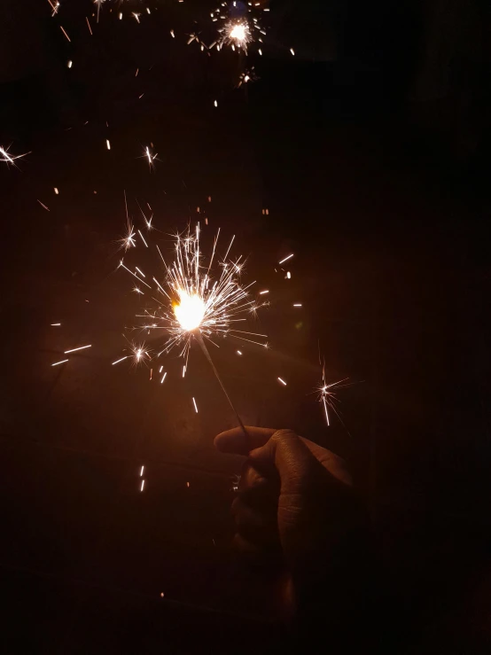 a person is holding a sparkler with their hands