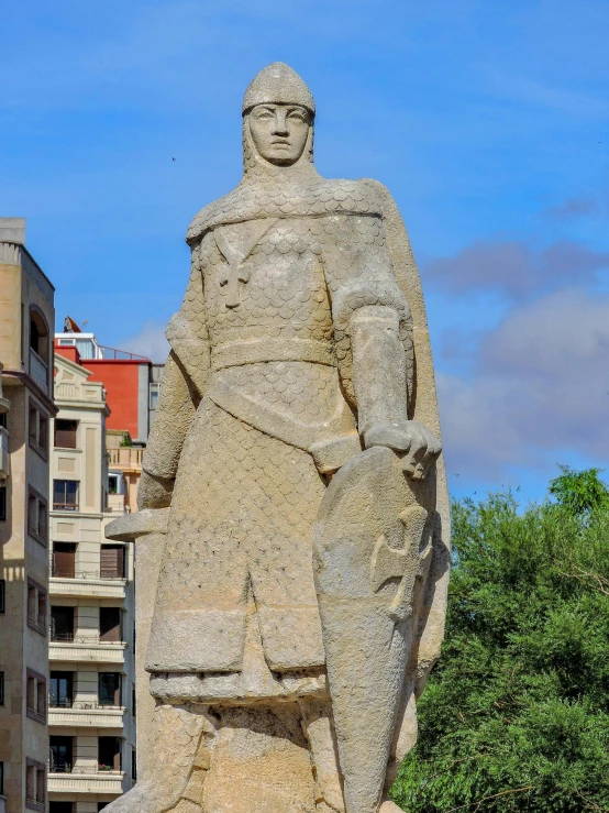 a giant statue standing in front of tall buildings