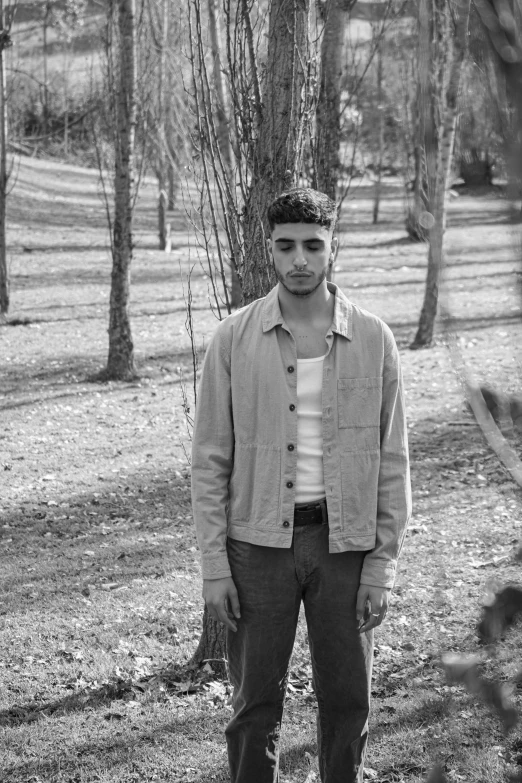 a man standing in the grass in a park