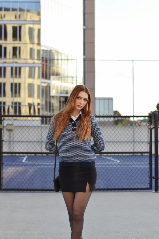 a young red - haired woman wearing black stockings and heels