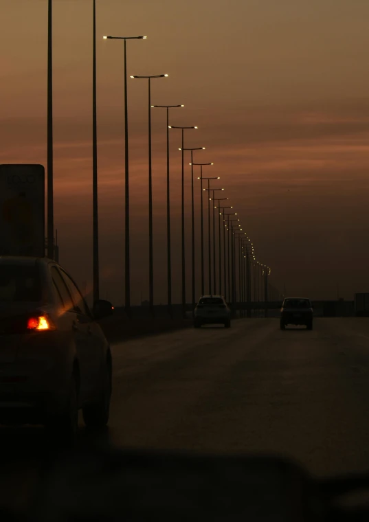 car lights on the road at dusk with street lights