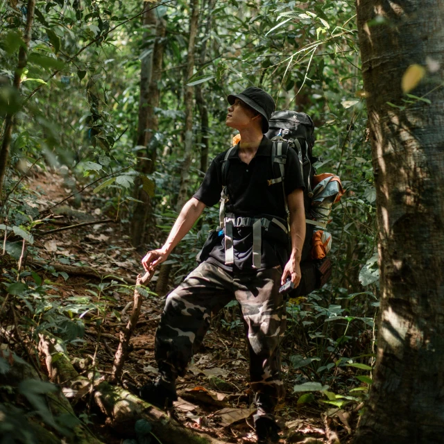 a man wearing a hat while hiking through a forest