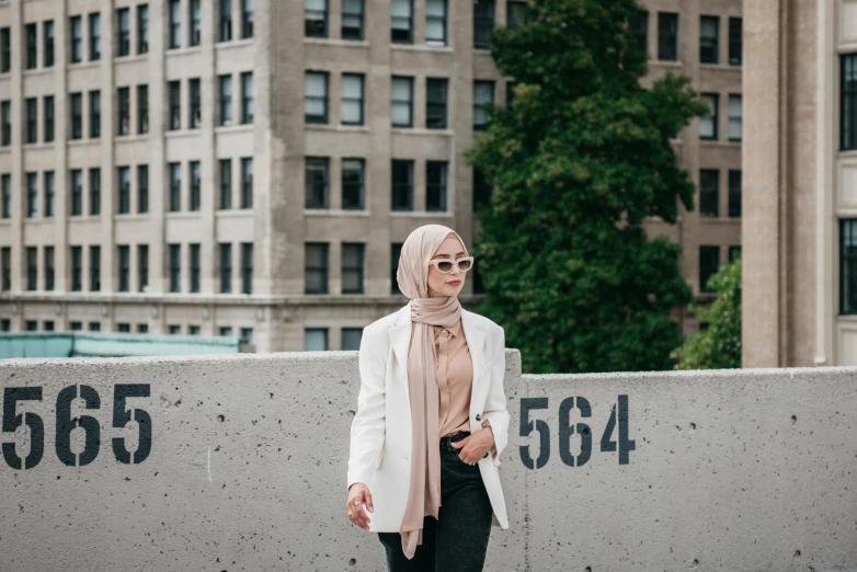 a person standing near a wall with a building in the background