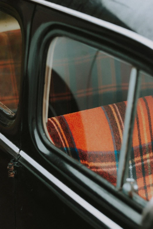 a reflection in a car window of a blanket wrapped to the side