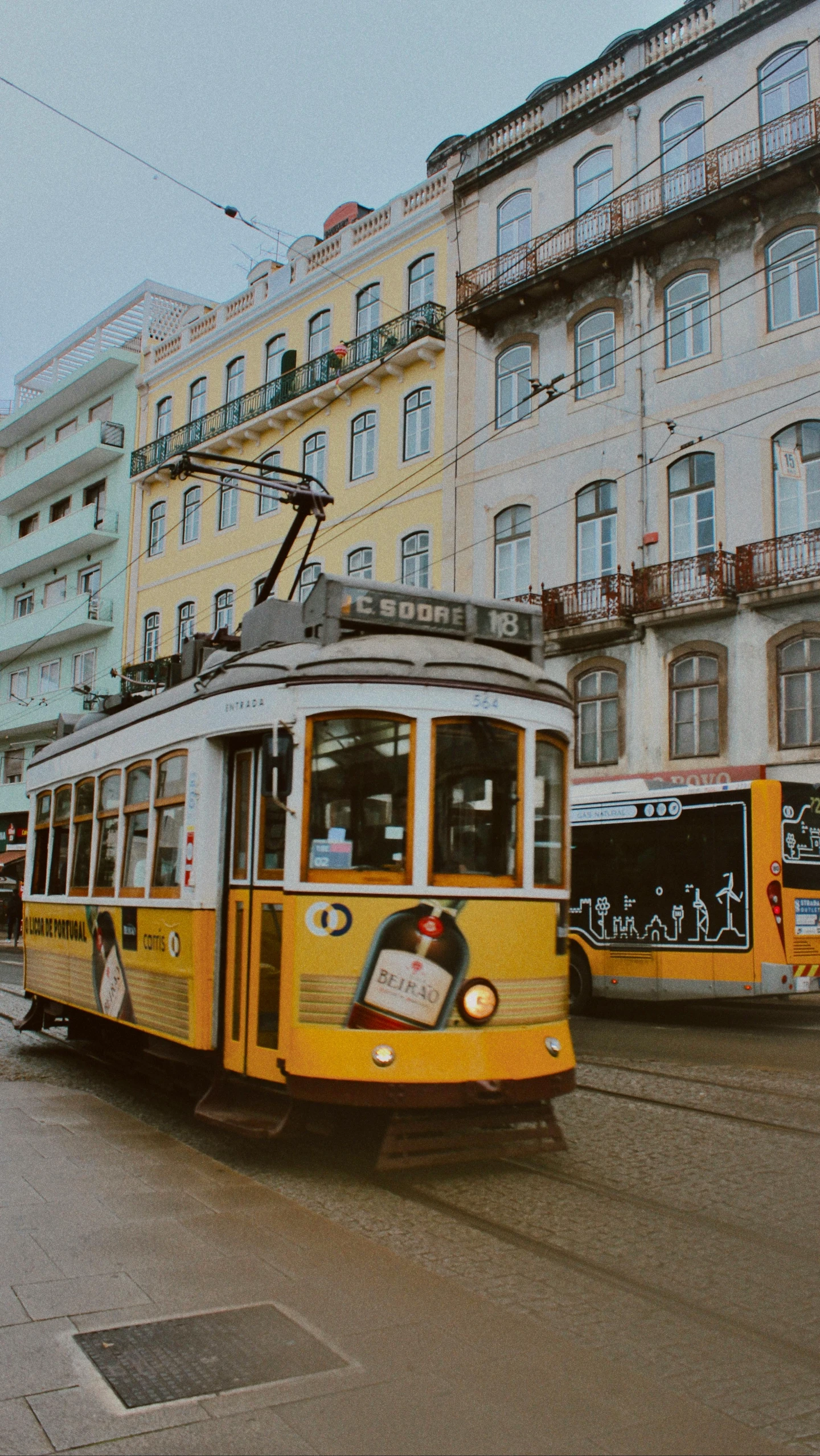 a yellow trolley is going down the street near buildings