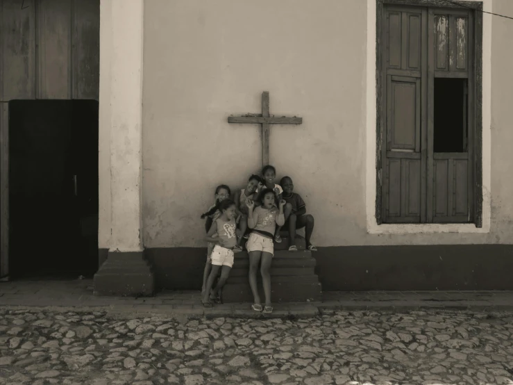 four girls are standing in front of a cross