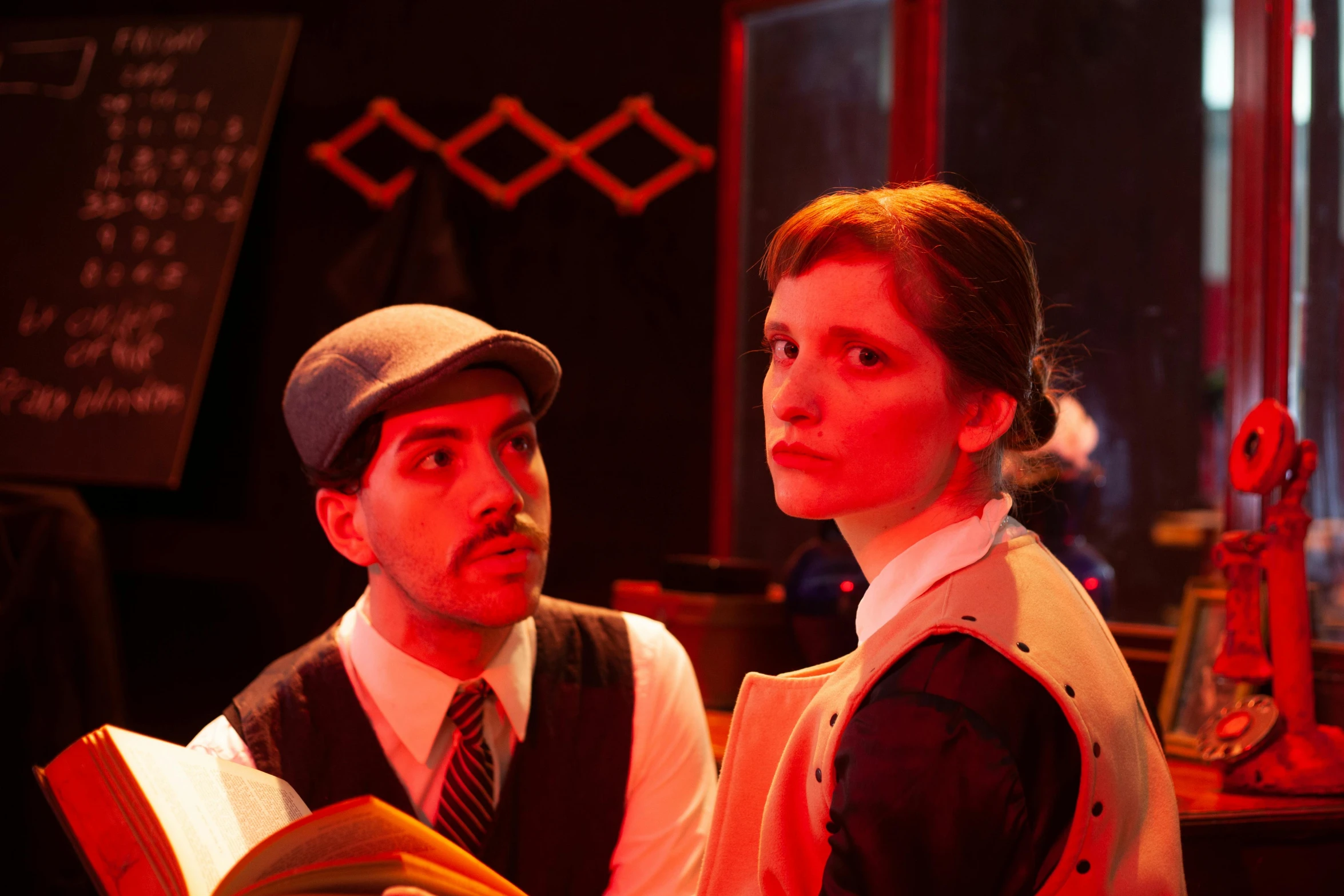 man and woman dressed in period - era costumes reading together