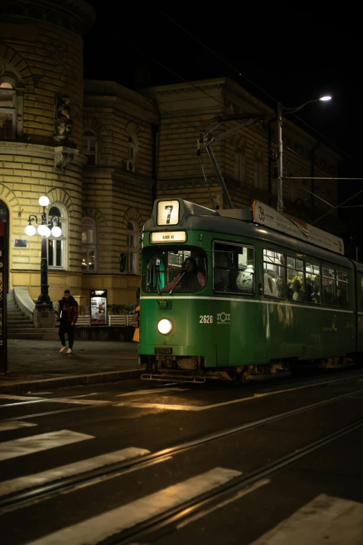 a green trolley in the middle of a road