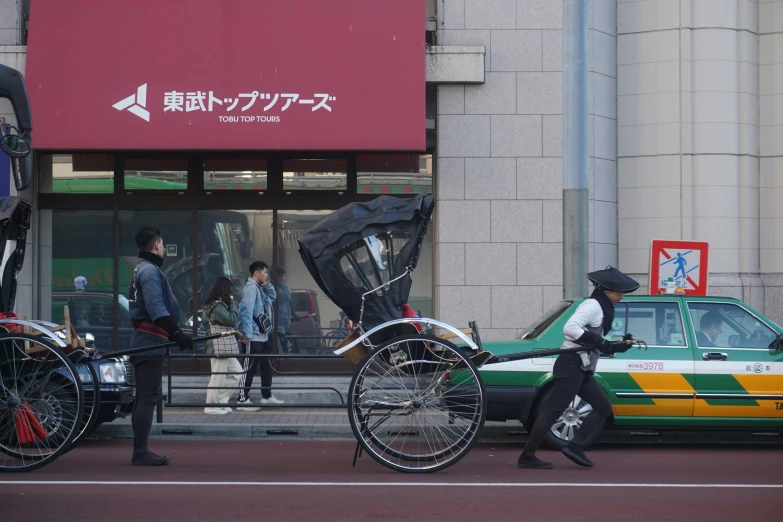 a man pulling two old style carriages on the road