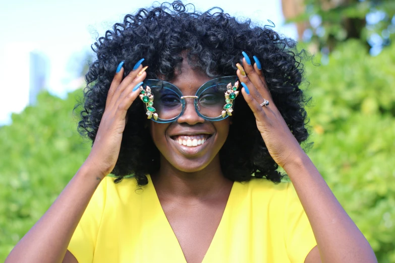 a young woman wears sunglasses while covering her face