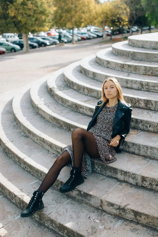 the woman is sitting on the steps in the city