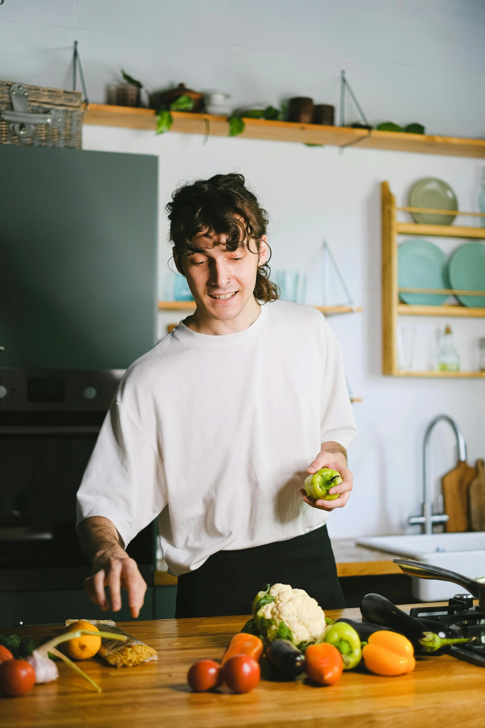 a woman in the kitchen is holding an apple