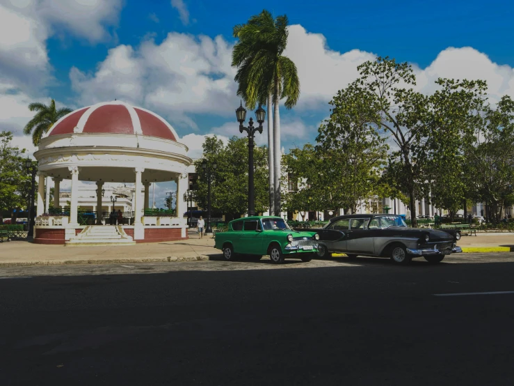 two classic cars are parked under a dome