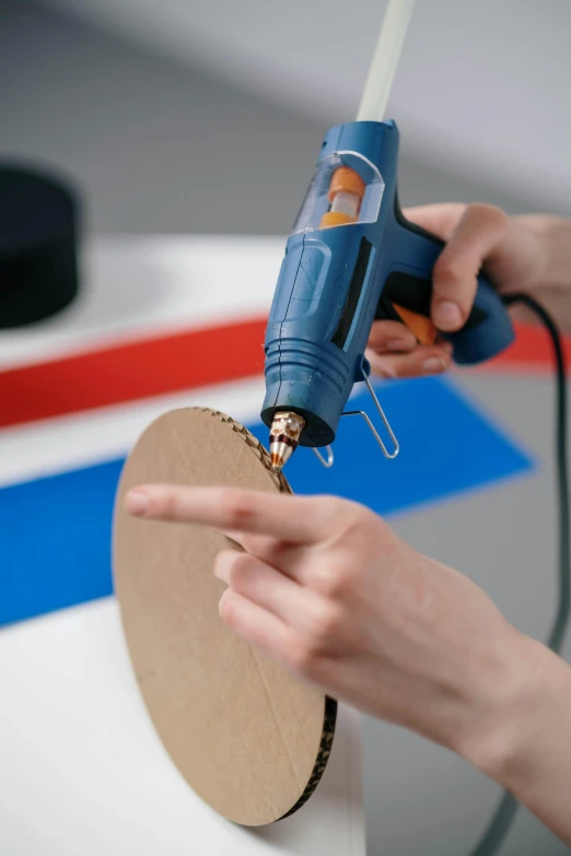 a person uses an electric drill to cut paper