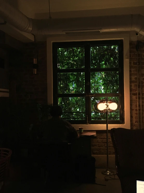 dark room with large window and furniture in foreground