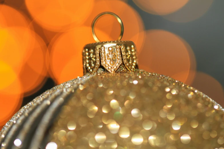 a glittered christmas ball ornament and ring on a table