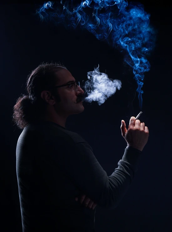 man in black shirt smoking a cigarette and blue smoke