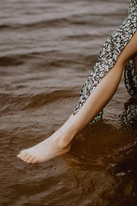 there is a woman's legs and ankles in the water