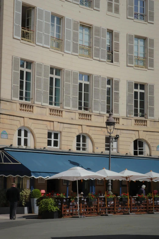 an old building that has several tables and umbrellas