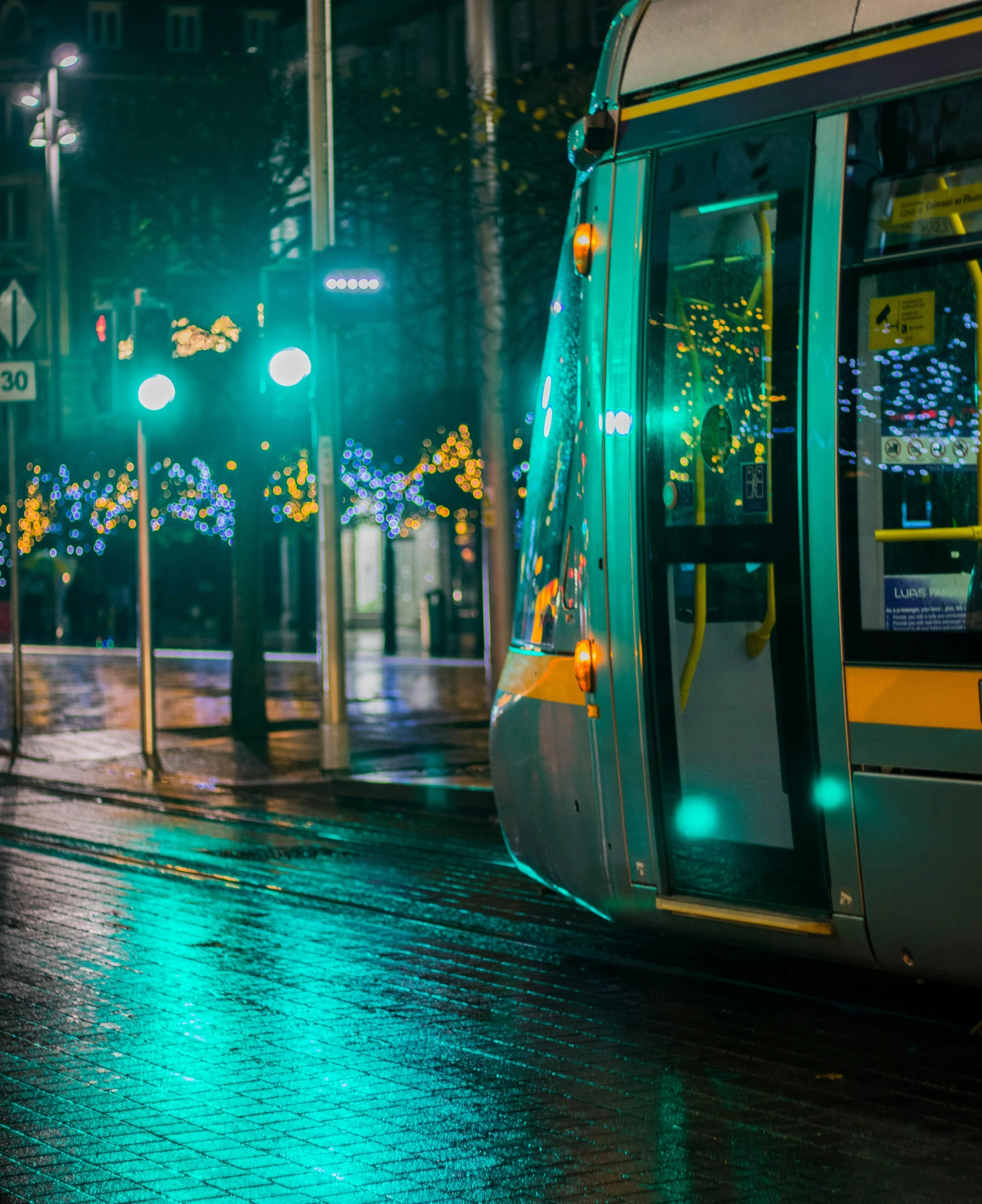 a bus sitting in the street at night on a rainy day