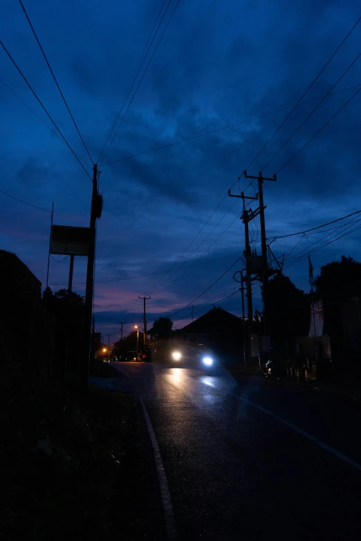 a very dark street with some cars on it