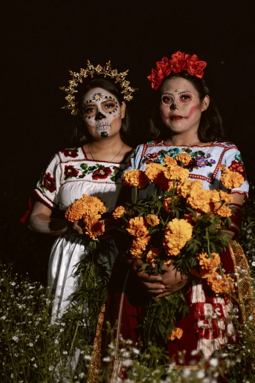 two women with painted faces holding flowers