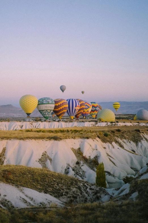 a row of balloons with mountains in the background