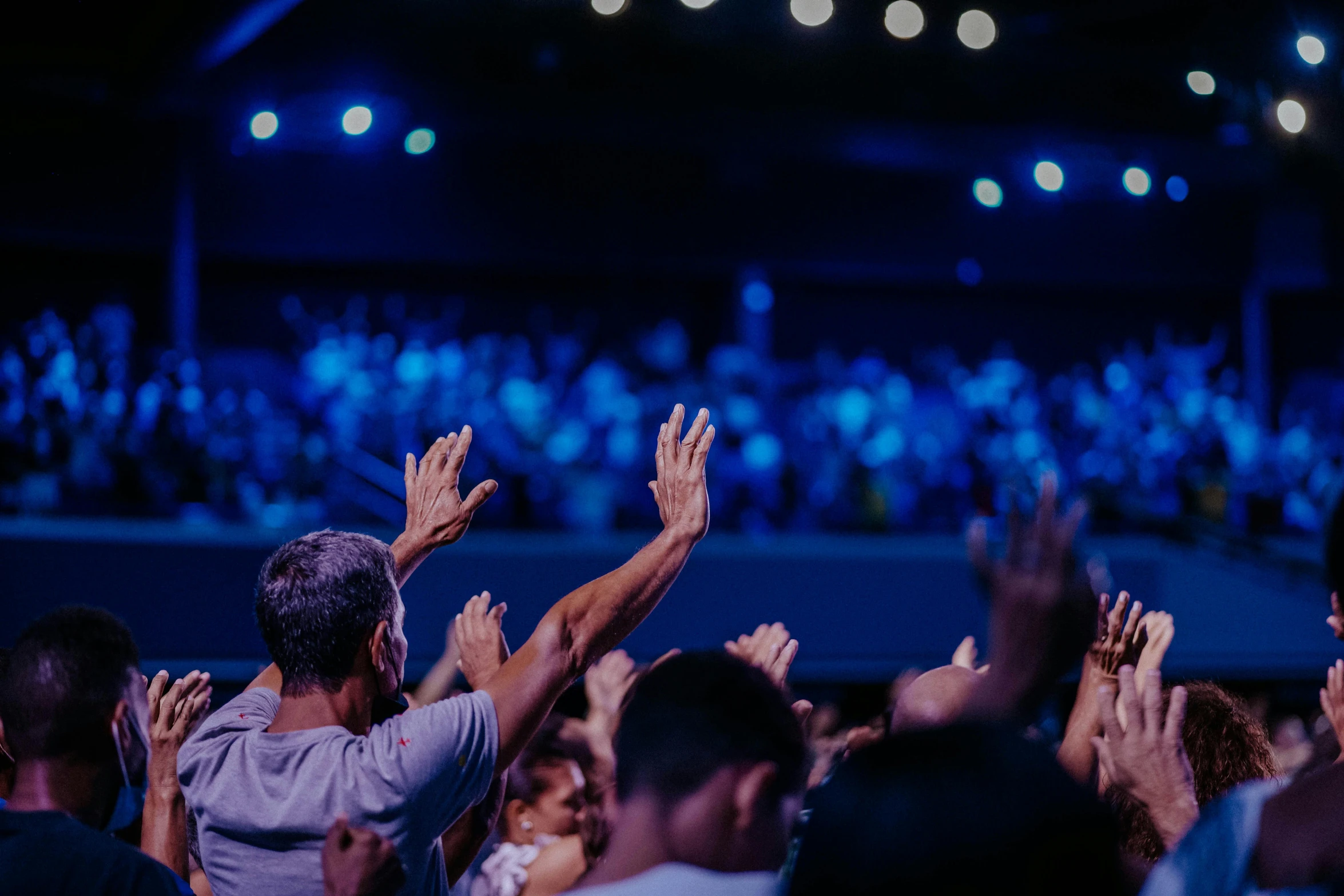 people clapping in front of a crowd with their hands up