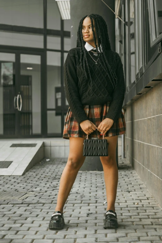 woman in black and white outfit standing in front of an apartment building