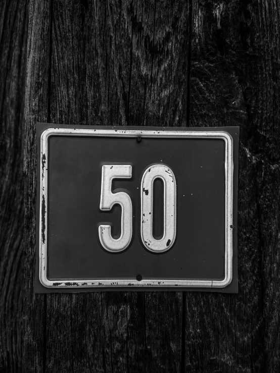 a number plate is displayed on the side of the wooden door