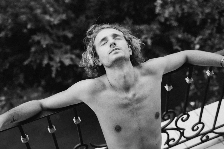 black and white pograph of  man leaning on rail