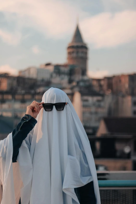 a man wearing glasses covers his eyes by a blanket