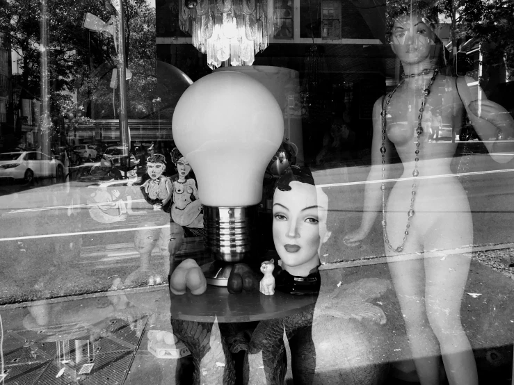 mannequins are posed and a light bulb is hanging