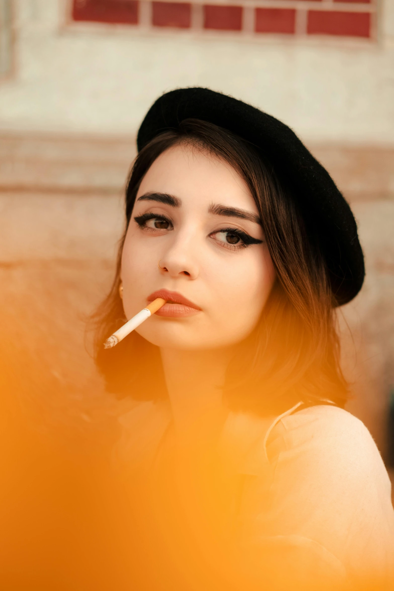 a girl in a hat is smoking a cigarette