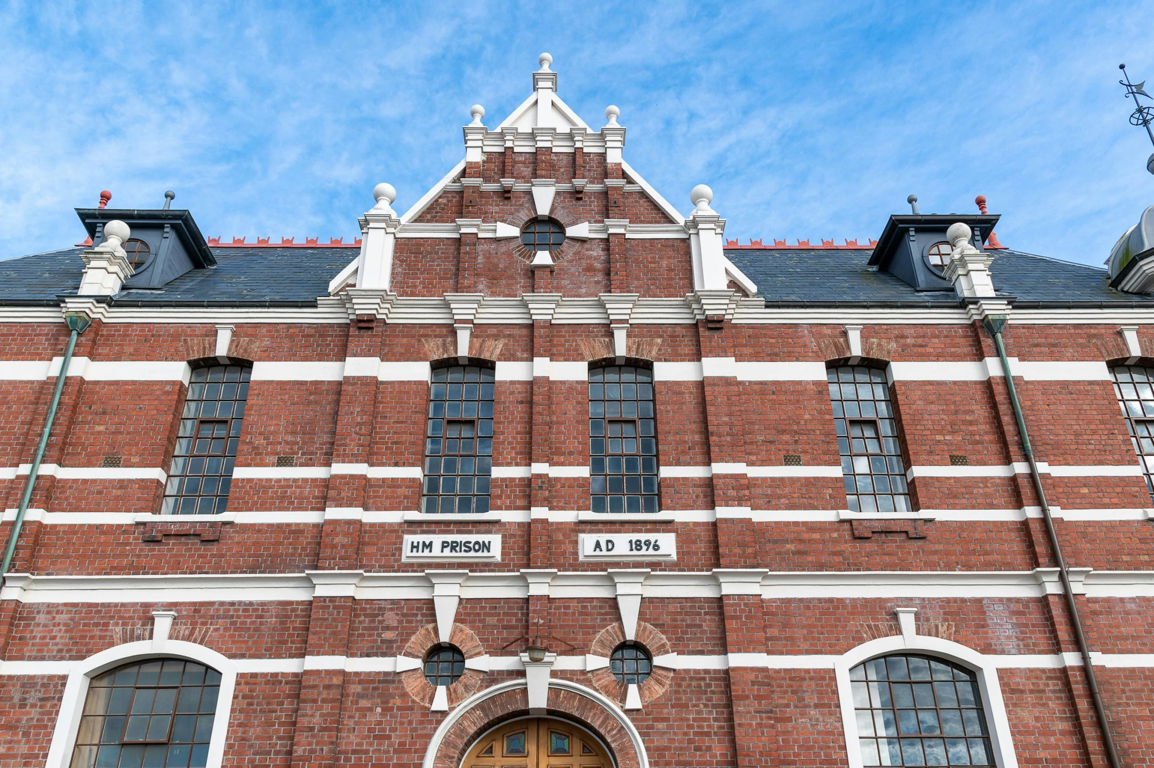 a brick building with multiple windows and two clocks