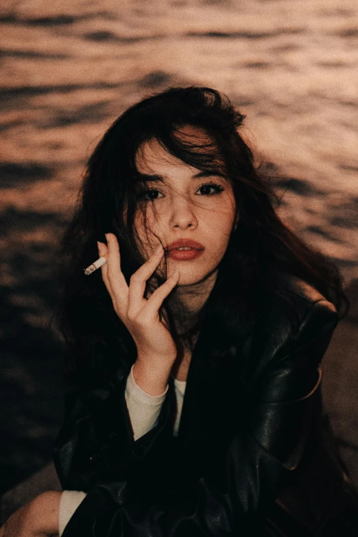 a woman with red lipstick sitting and smoking a cigarette